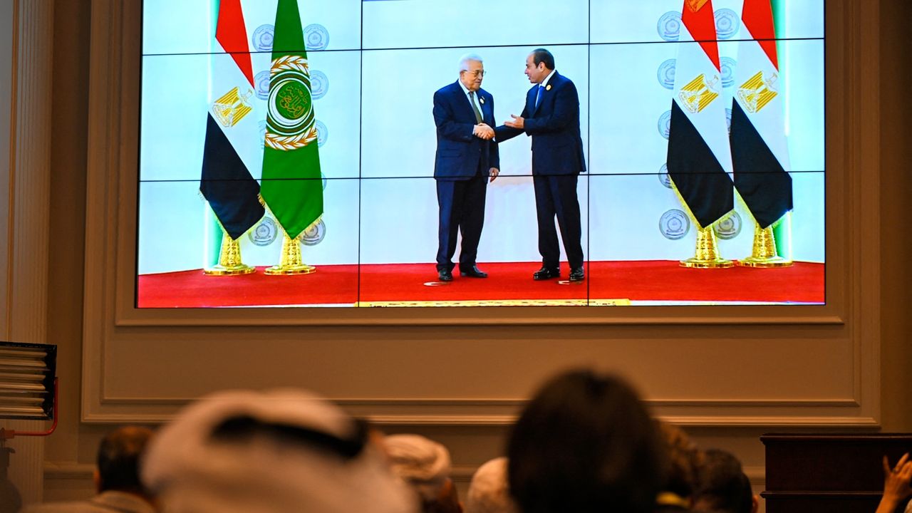 Crowds watching big screen showing Egypt&#039;s President Abdel Fattah el-Sisi and Palestinian President Mahmud Abbas at Arab League summit in Cairo