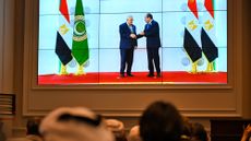 Crowds watching big screen showing Egypt's President Abdel Fattah al-Sisi and Palestinian President Mahmud Abbas at Arab League summit in Cairo