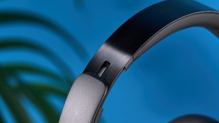 a pair of black baseus bowie 30 max headphones with soft rounded square cups with a blue background