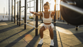 Woman doing a squat at outdoor gym