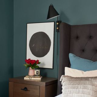 teal bedroom with grey bed and bedside table