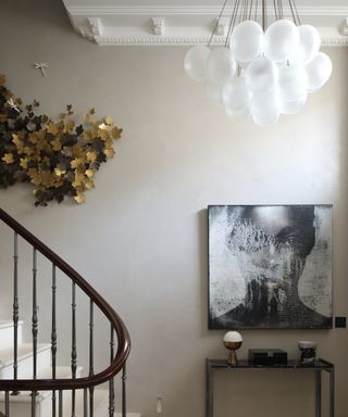modern hallway with large art and chandelier