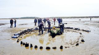 people excavating seahenge on a beach
