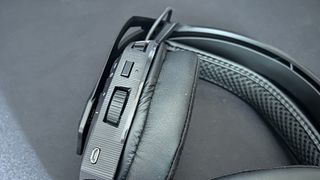 Nacon RIG 800 Pro HS headset on a matte black surface - close up of controls on left earcup