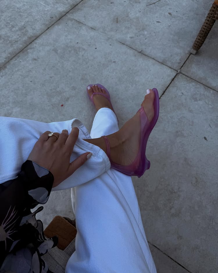 An image of @ariellecharnas wearing Chlo&amp;eacute;'s TPU heeled flip-flops, one of the biggest jelly shoe trends of 2026.