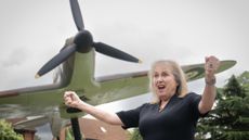 Susan Hall cheering in front of a spitfire