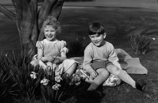 23rd April 1954: Princess Anne and Prince Charles sitting on a picnic rug in the grounds of the Royal Lodge at Windsor. (Photo by Lisa Sheridan/Studio Lisa/Getty Images)