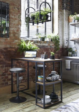 industrial style open plan kitchen with small breakfast bar with storage, bar stools, exposed brick