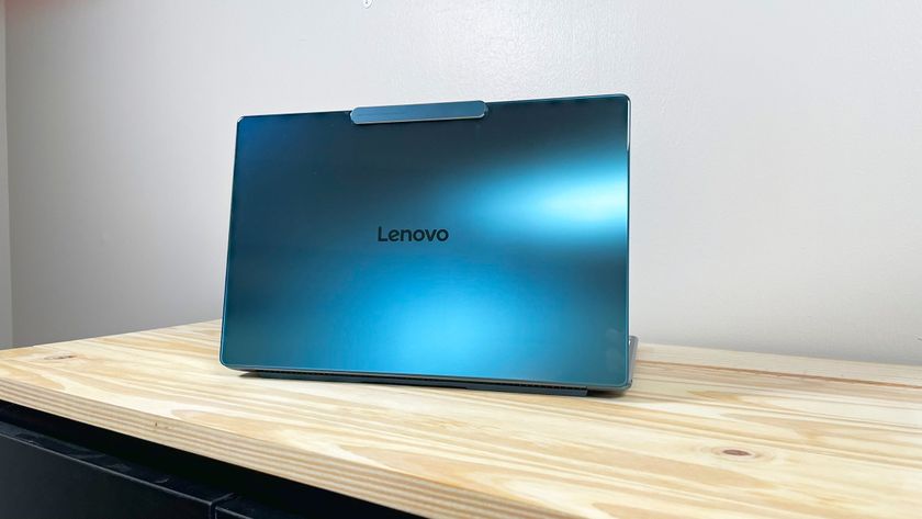 The glossy blue lid of the Lenovo Yoga Slim 9i on display on a wood table