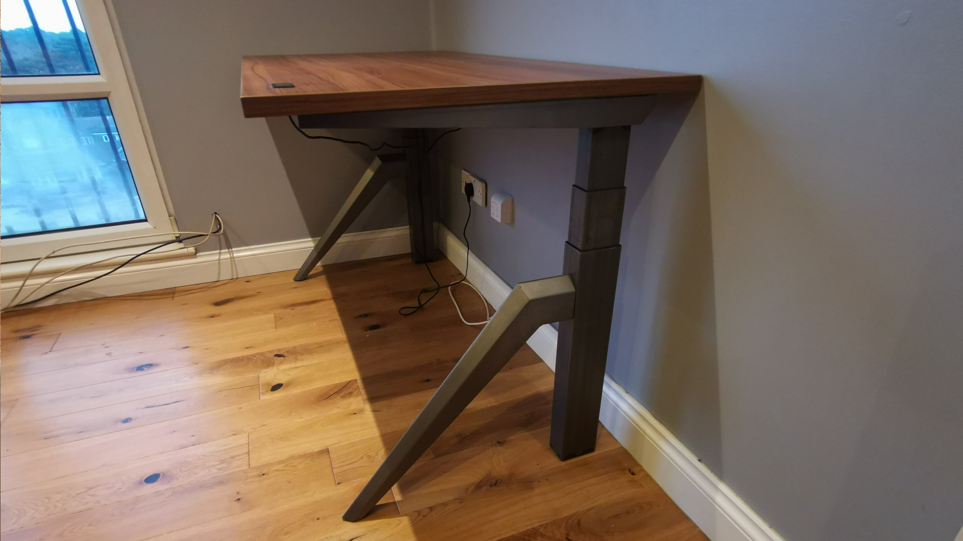 The Friska Primo Designer standing desk against a wall