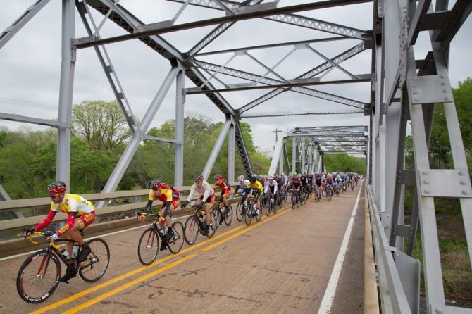 Francisco Mancebo, defending champion and NRC points leader, leads teammate and overall race leader Nate English as the peloton crosses a steel bridge south of Natural Dam, Arkansas.