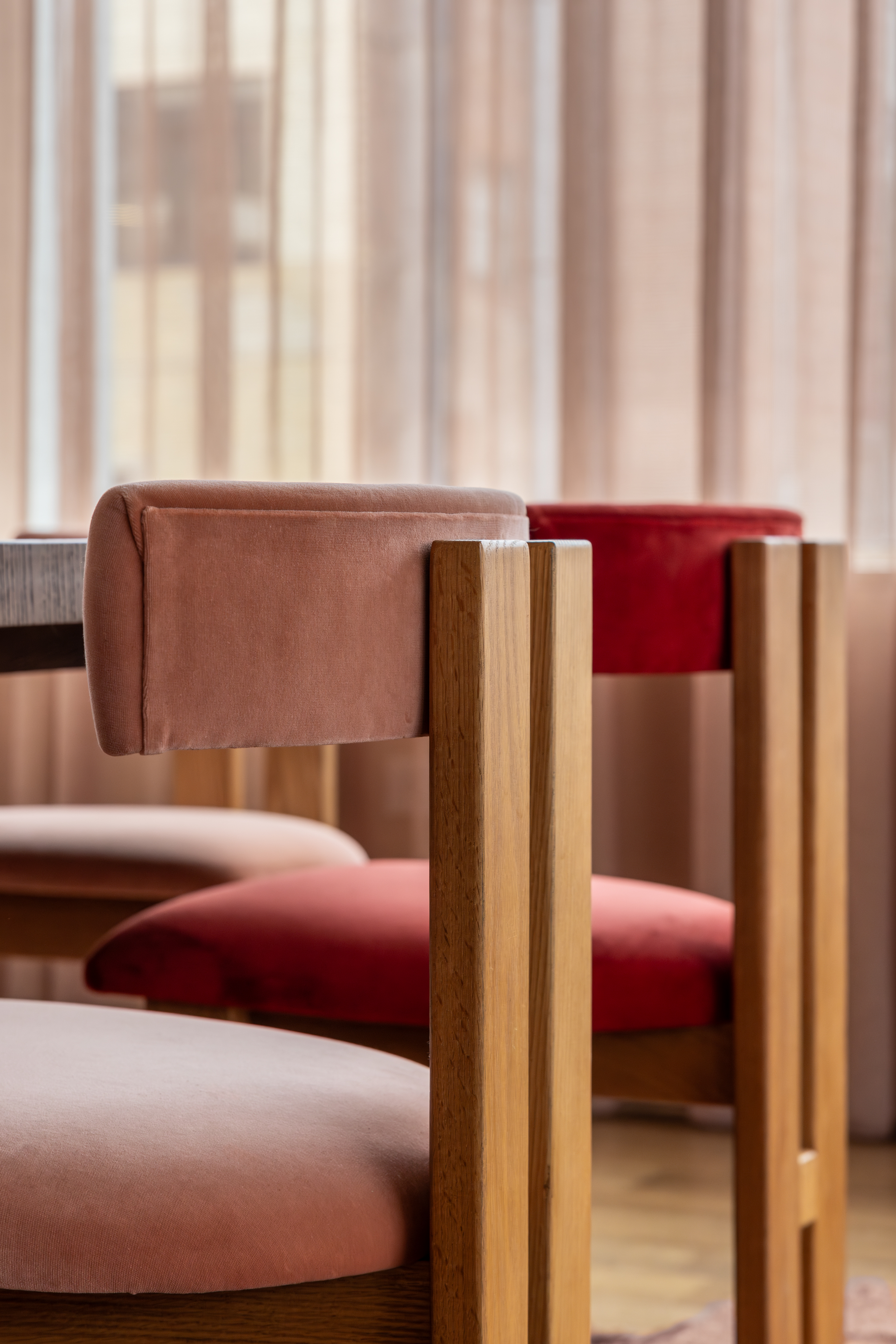A dining room with pink upholstered chairs
