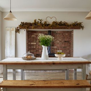Rustic-style dining table in front of large open fireplace