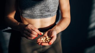 Woman holding handful of peanuts wearing workout clothes