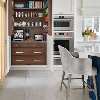 An open pantry with small applieances in a kitchen