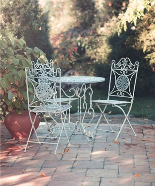 Metal garden furniture with wildflowers behind