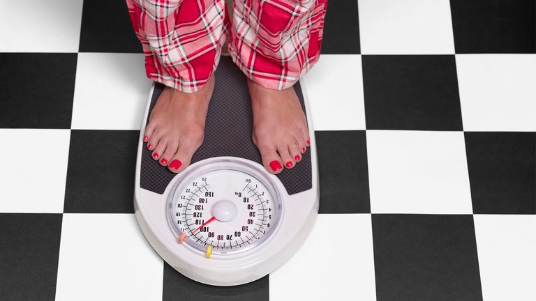 Weight loss plateau: Image shows person on weighing scales