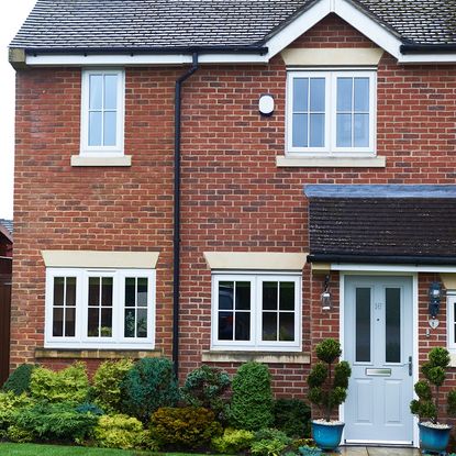 red brick wall mansion with roof top white window and door