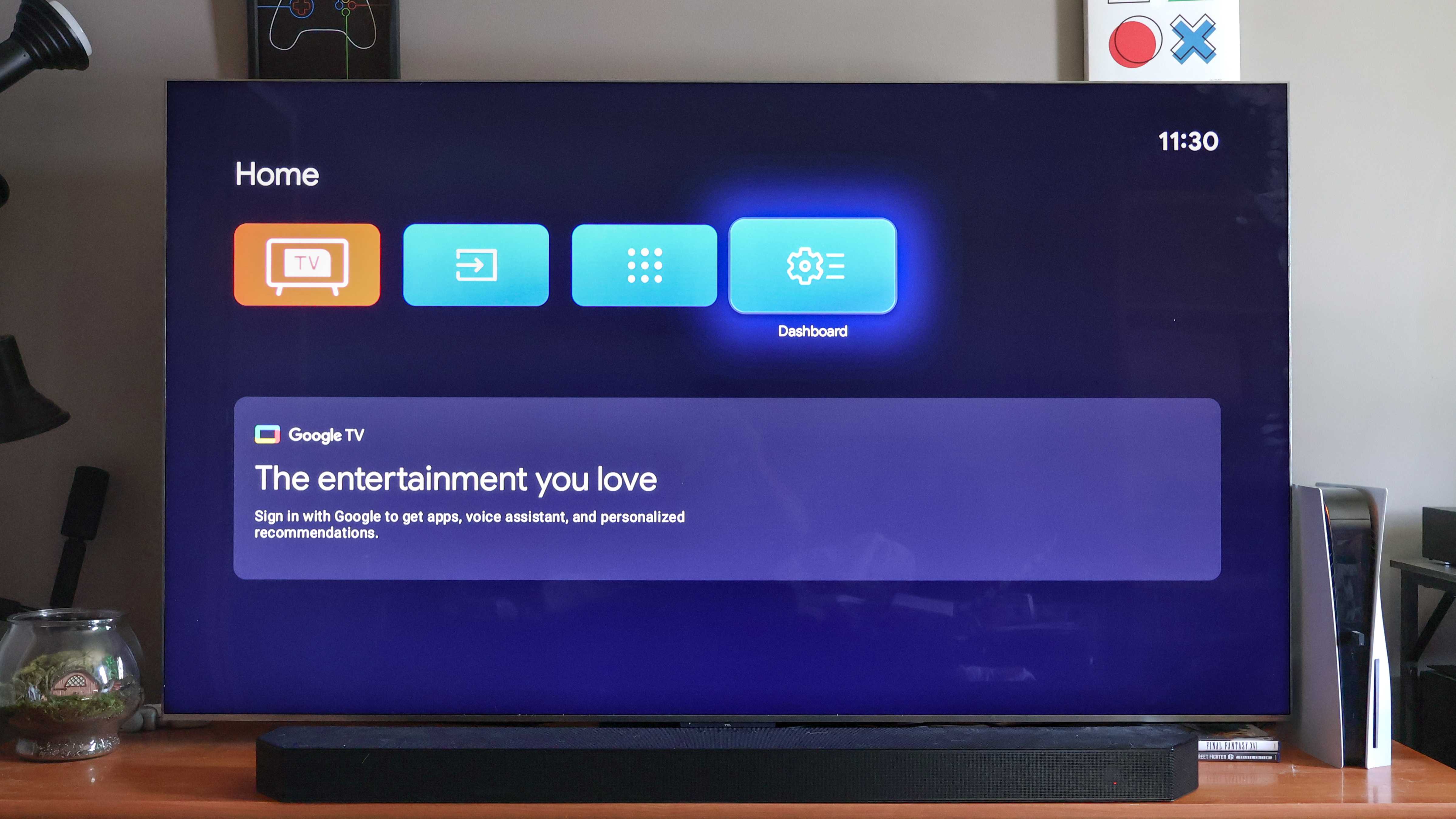 A TV on a media console displaying the Google TV home screen when the software is in Basic Mode. There are no apps or advertisements on the screen, just various, selectable inputs.