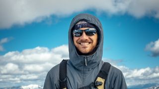 Hiker in the mountains with puffy clouds in the background