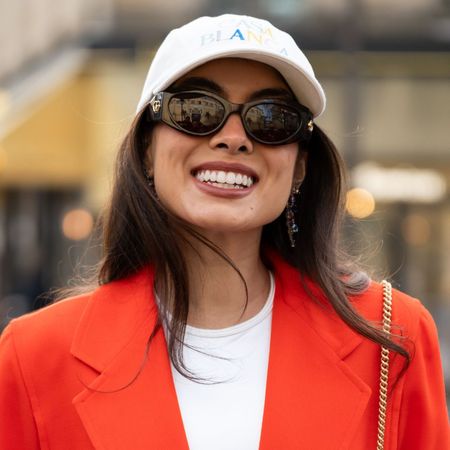 woman with white cap and red blazer and sunglasses