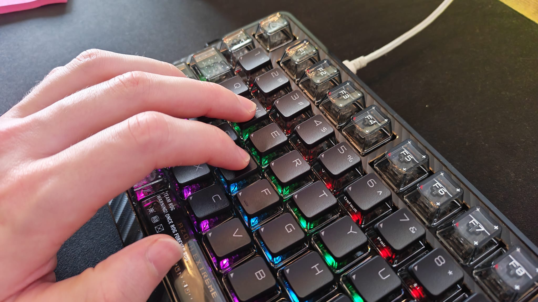 A reviewer's hand on the Asus ROG Azoth Extreme 20