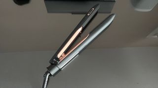 The Panasonic EH-HS99 hair straightener laying on a glass countertop