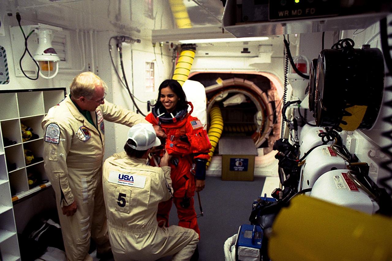 Kalpana Chawla being assisted in her flight suit prior to launch on STS-87.