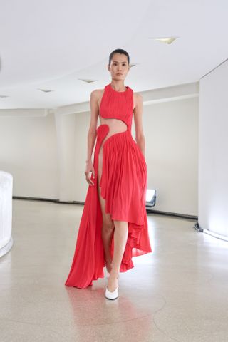 a model wears a red cutout dress