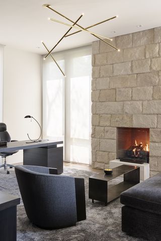 A home office with a fireplace and seating area