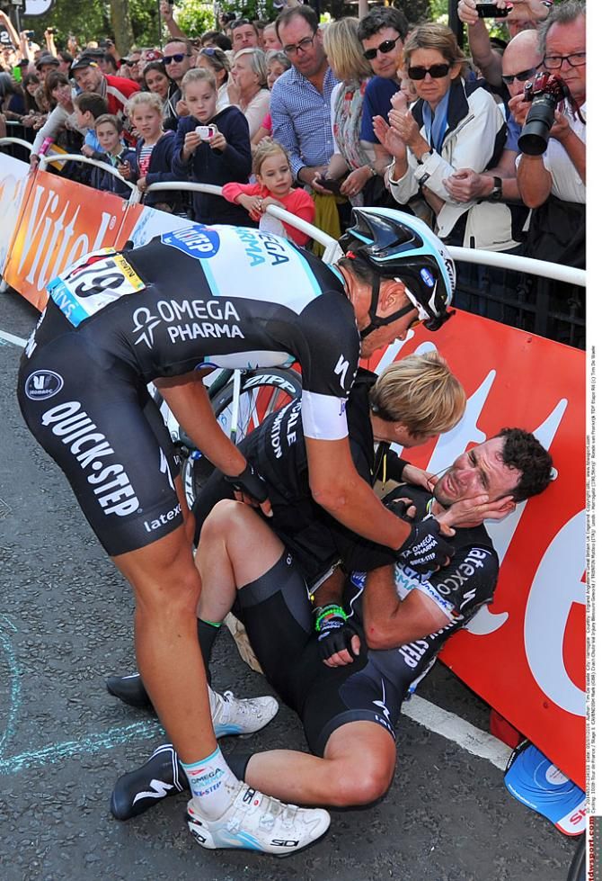 Mark Cavendish rests against a barrier after his crash