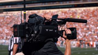 A Sony camera and cameraman on the sidelines of a Texas Longhorns game. 