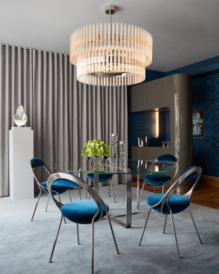 A dining room with a lighting piece suspended above