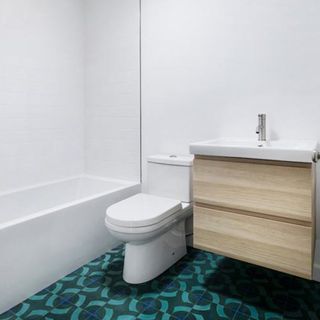 bathroom with white wall commode and bathtub