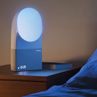 withings aura smart sleep system and book on wooden table near bed