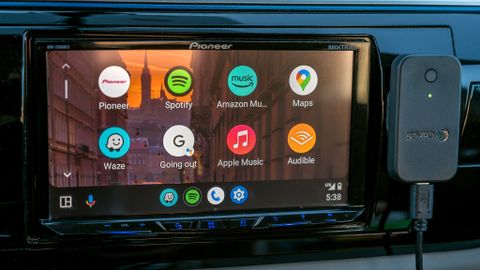 Carsifi wireless Android Auto adapter next to infotainment screen.