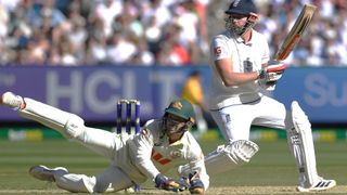 England tailend batsman Gus Atkinson gets a ball away watched by a sprawling Alex Carey, the Australian wicket-keeper, during the 4th Test