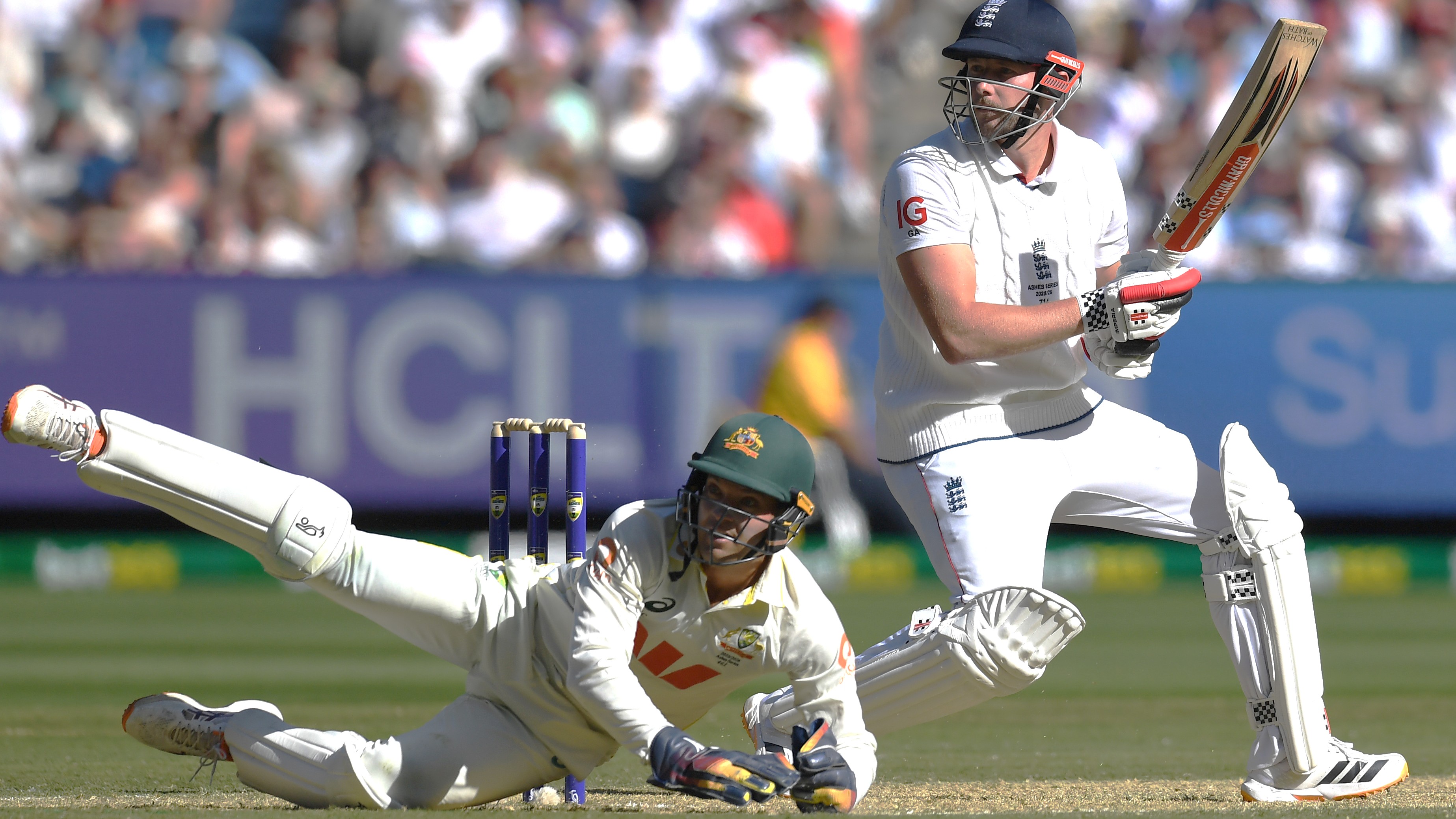 England tailend batsman Gus Atkinson gets a ball away watched by a sprawling Alex Carey, the Australian wicket-keeper, during the 4th Test 