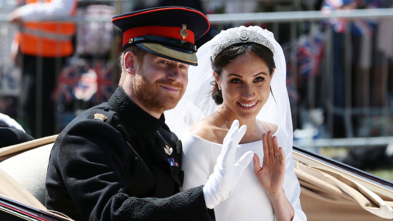 Prince Harry, Duke of Sussex and Meghan, Duchess of Sussex wave from the Ascot Landau Carriage during their carriage procession on Castle Hill outside Windsor Castle in Windsor, on May 19, 2018 after their wedding ceremony.