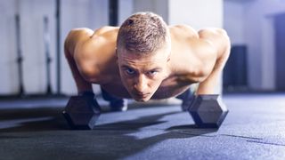 Man doing renegade rows with hex dumbbells