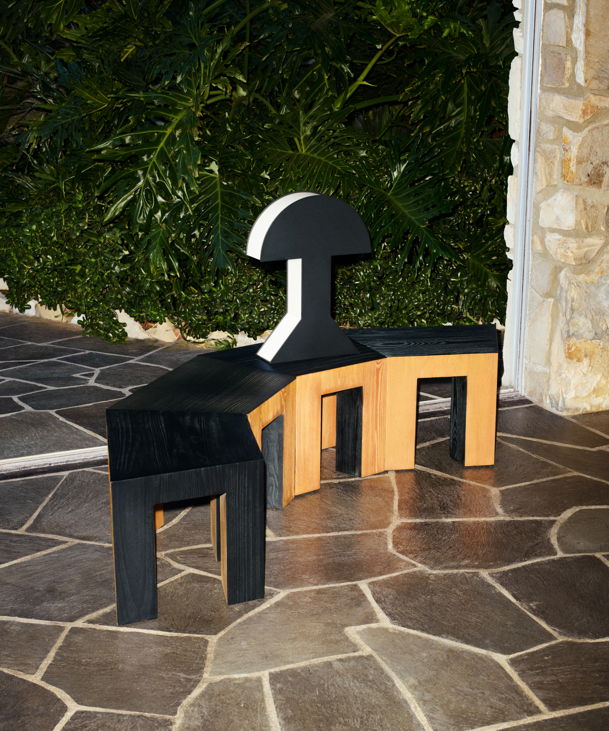 Kelly Wearstler x H&amp;amp;M Home wooden side tables arranged in a semicircle, topped with a 2D-look black-and-white table lamp.