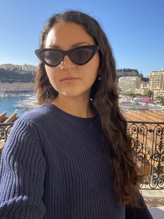 Woman in navy sweater with sunglasses