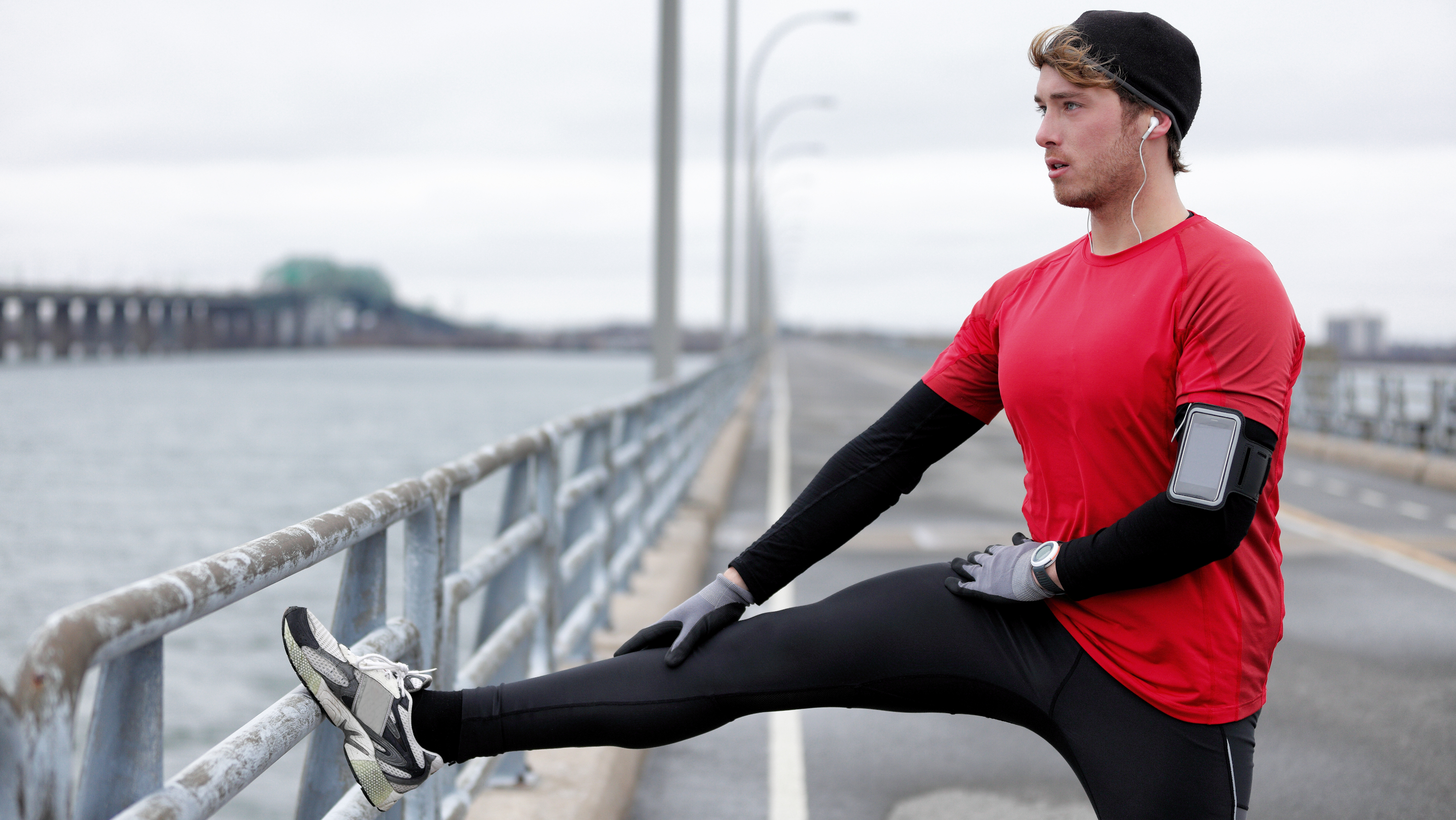 a runner stretching on a bridge