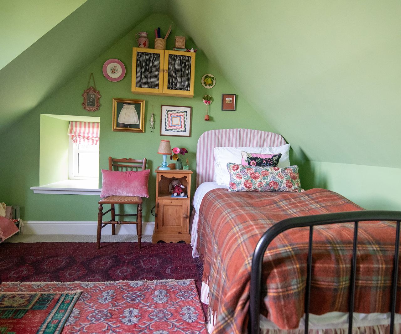 A vaulted ceiling in a green walled bedroom