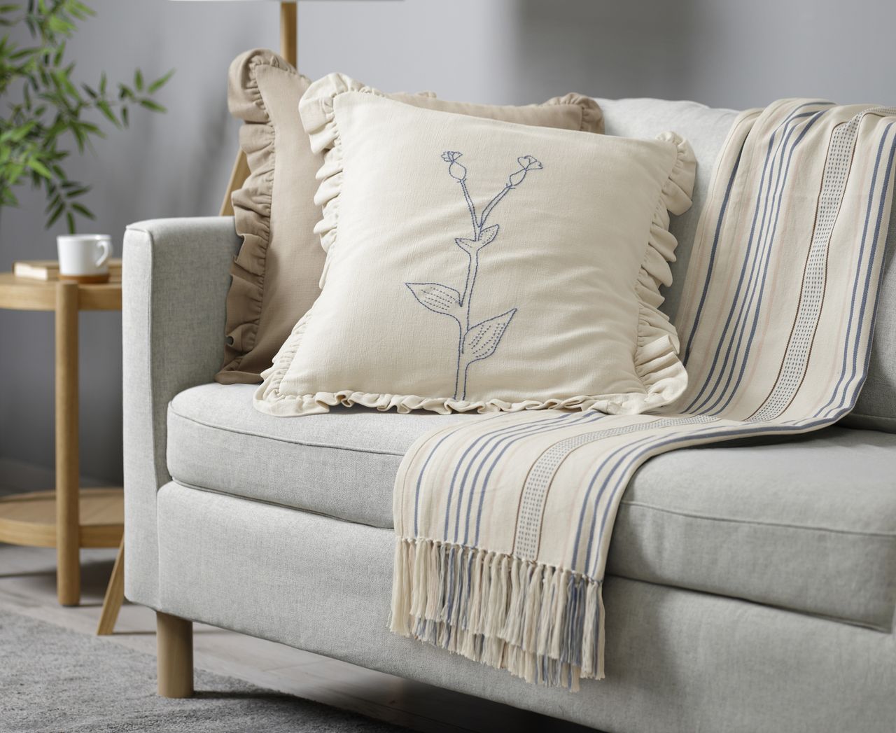 A living room with a grey sofa and Scandi-style throw pillows