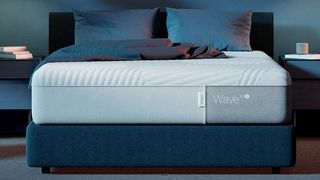 Casper Wave Hybrid Snow review: The mattress on placed on a dark blue bedframe in a bedroom