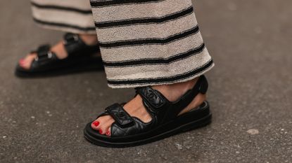 Close up of woman's feet wearing Chanel sandals