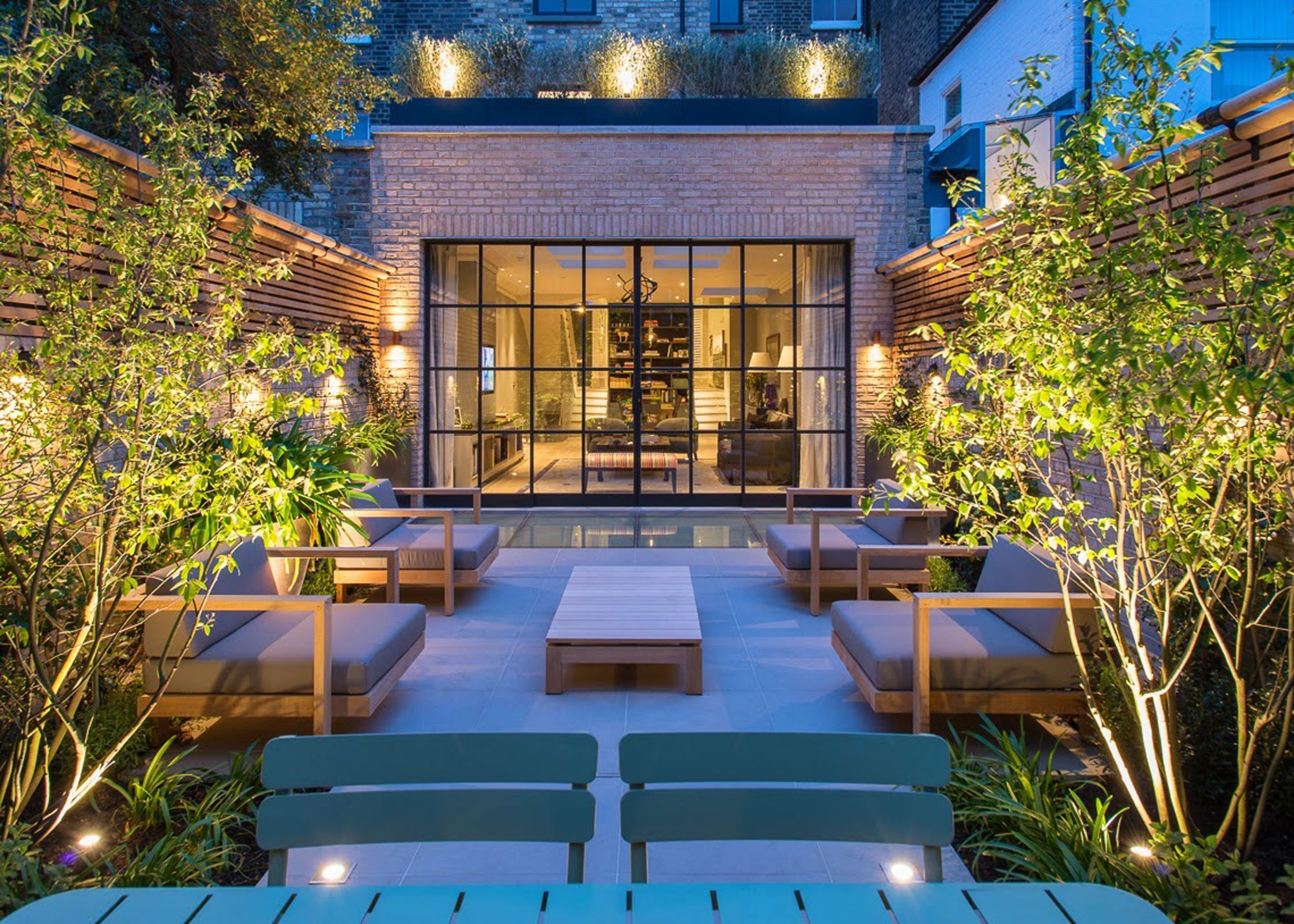 modern urban courtyard garden with lit trees