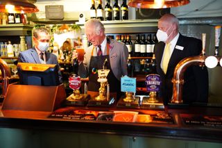 PONTHIR, WALES - JULY 09: Prince Charles, Prince of Wales tries some Butty Bach (a Welsh term meaning 'little friend') ale during a visit to Ponthir House Inn, one of the latest projects opened with a Community Services Fund grant from 'Pub is the Hub', on July 9, 2021 in Ponthir, near Newport, Wales. The prince is meeting staff, pub regulars and members of the local community that have benefitted from the pub's services and log cabin shop during lockdown, as part of a week long tour of Wales for Wales Week. (Photo by Ben Birchall - WPA Pool/Getty Images)