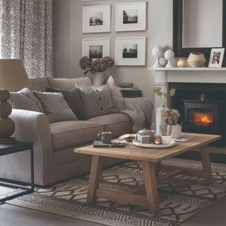 A living room with a grey sofa and matching knitted throw and cushions